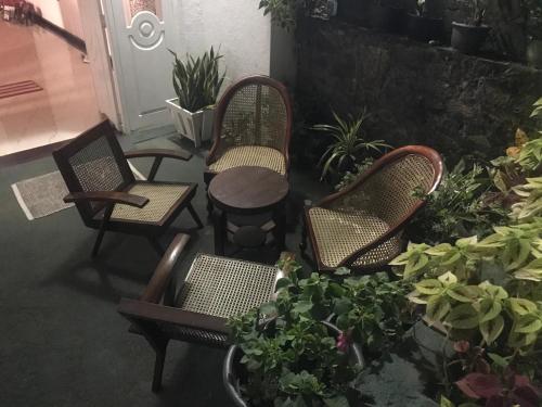a group of chairs and a table and some plants at Kande Home in Kandy
