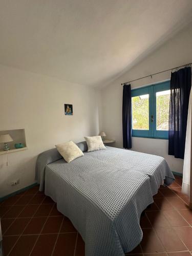 a bedroom with a large bed with two pillows on it at Sun, light and sea in Porto Rafael in Porto Rafael