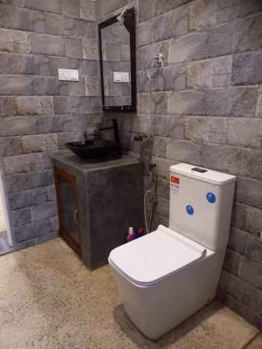 a bathroom with a toilet and a sink at Cozy Cottage in Ahangama