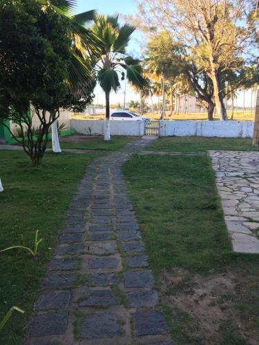 a stone walkway in a park with palm trees at Pousada Cataventos in Sirinhaém