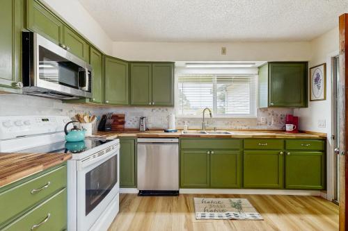 a kitchen with green cabinets and a sink at Mad River Retreat in McKinleyville