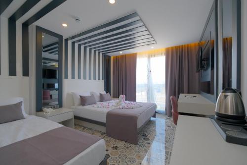 a bedroom with two beds and a large window at Black Royal Belek in Belek