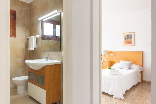 a bathroom with a sink and a bed at Chalet Muro en Mallorca in Playa de Muro