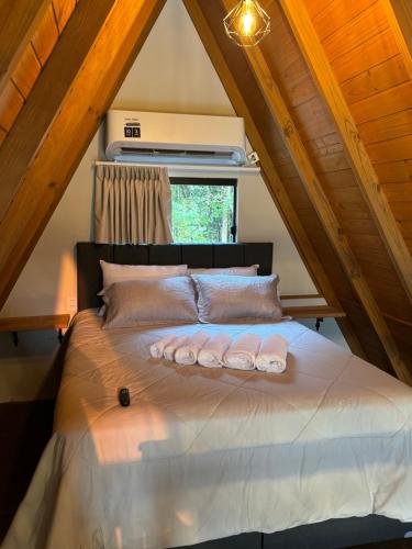 a bedroom with a bed in the attic at Chalé Dovale in Sambaqui