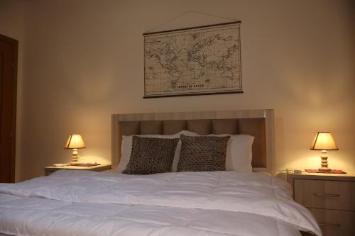 a bedroom with a white bed with two lamps at Villa Berat in Berat