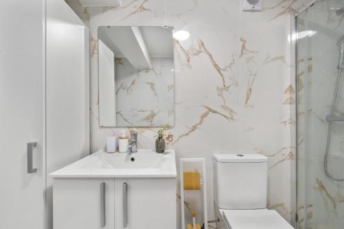 a bathroom with a toilet and a sink and a mirror at MBird 19 Estoril Apartments 203 in Estoril