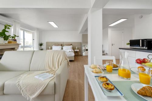 a living room with a table with breakfast foods and orange juice at MBird 19 Estoril Apartments 203 in Estoril