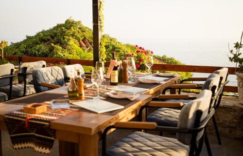 a long wooden table with chairs and wine bottles at Villa Terra Promessa in Ulcinj