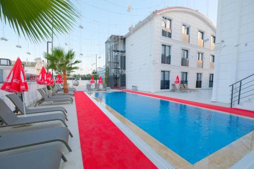 a swimming pool with a red carpet next to a building at Black Royal Belek in Belek