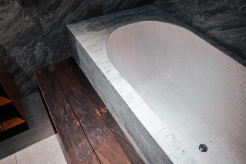 a concrete wall with a wooden floor in a room at Tropical Space in Ubud