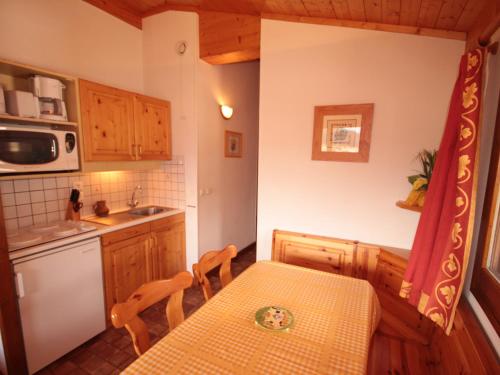 La cuisine est équipée d'une table, d'un évier et d'un four micro-ondes. dans l'établissement Appartement 2 pièces cabine pour 6 personnes aux Saisies, proche des pistes et commerces - FR-1-293-6, à Hauteluce