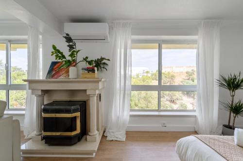 a living room with a fireplace with a tv at MBird 19 Estoril Apartments 203 in Estoril