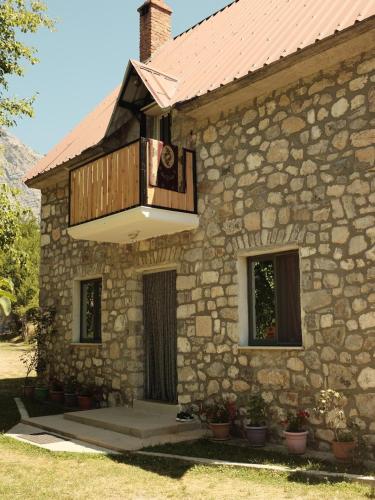 a stone building with a balcony on top of it at Bujtina Milani in Theth