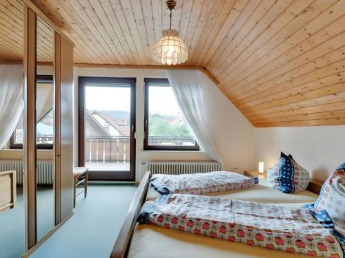 two beds in a room with a wooden ceiling at Ferienwohnung Sanna in Niedereschach