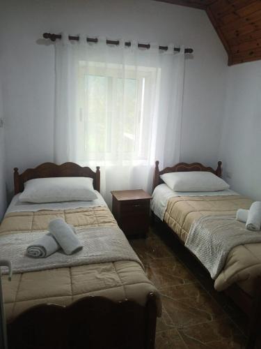 a bedroom with two beds and a window at Bujtina Milani in Theth