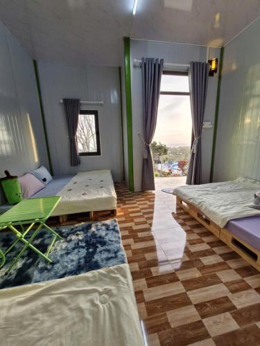 a room with two beds and a large window at SORA HOME STAY Ke Ga in Láng Văn Kê