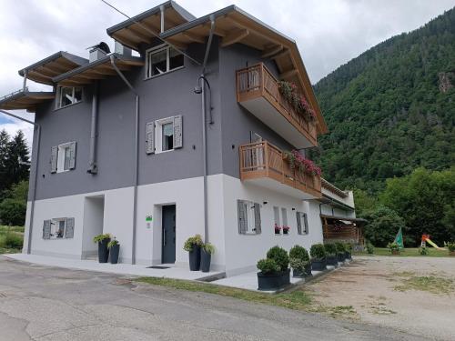 a building with balconies and potted plants on it at Casa Nadia - Val di Sole Apartment in Piano