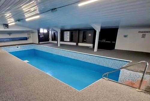 a large swimming pool in a building at 5Berth -Family Friendly -ParkingSpot -Heated Pool in St Austell