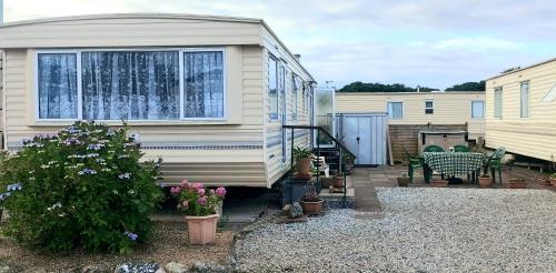 an exterior view of a mobile home with a patio at 5Berth -Family Friendly -ParkingSpot -Heated Pool in St Austell