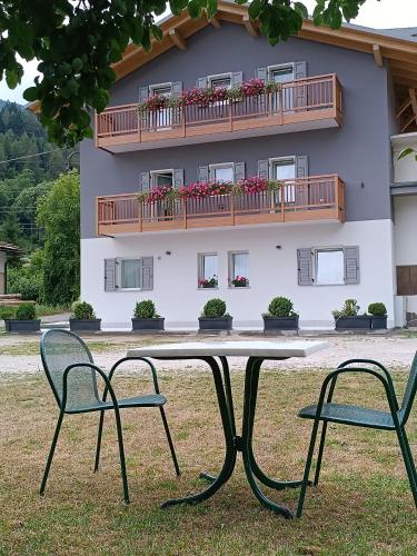 a table and two chairs in front of a building at Casa Nadia - Val di Sole Apartment in Piano