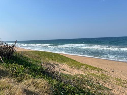 a sandy beach with the ocean in the background at Beachfront Hotel, La Mercy in Umhlanga