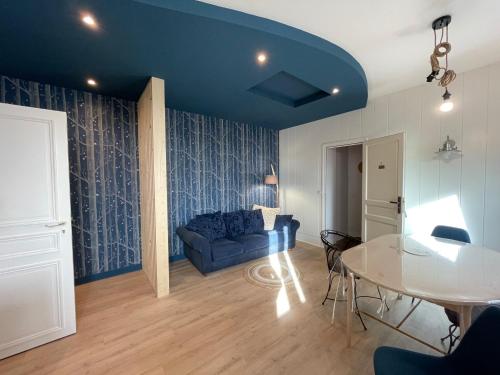 a living room with a blue couch and a table at Maunoury Citybreak in Chartres