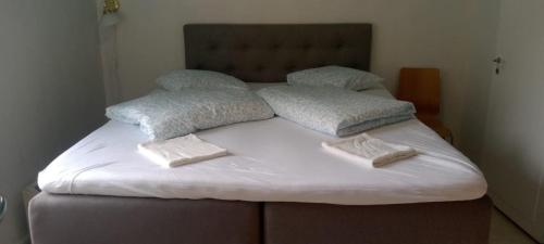 a bed with white sheets and pillows on it at Fjordshelter vintage townhouse in Tysso