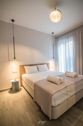 a bedroom with a large bed with two towels on it at Gialos Villas Paleochora in Palaiochóra