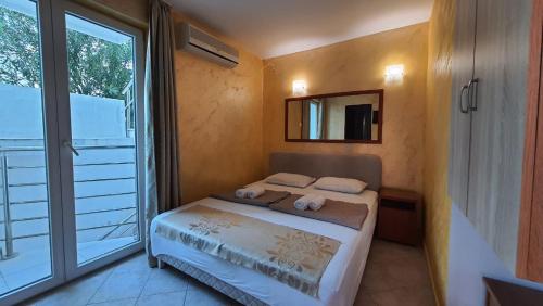 a bedroom with a bed and a large window at Villa Golf 2 in Budva
