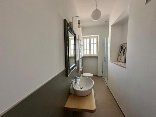 a bathroom with a sink and a mirror on the wall at Otto Trulli Apulian Country House in Noci
