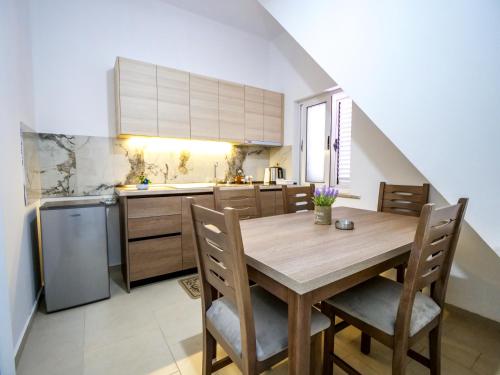 a kitchen with a wooden table and chairs at Daydream Villas, floor 1 in Shkodër