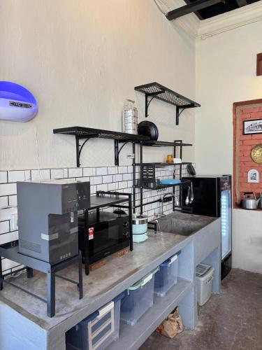 a kitchen with a counter with shelves and a counter top at Miner's House Ipoh in Ipoh