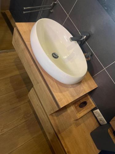 a white sink sitting on a wooden counter in a bathroom at City soul duplex apartment in Maribor