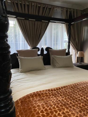 une chambre avec un grand lit à baldaquin dans l'établissement Estelle Family cottage, à Johannesbourg