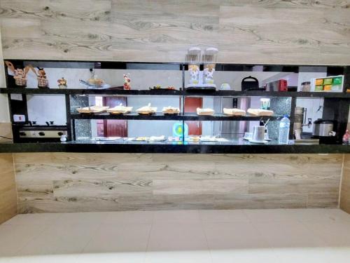 a counter with plates of food on display at Hotel Recanto do Sol in Cananéia