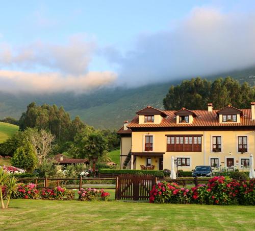 a large house with flowers in a yard at Casa de Aldea El Frade in Ribadesella