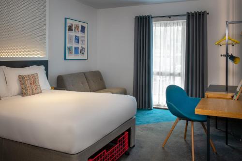 a bedroom with a bed and a desk and a chair at Lodge at Solent in Fareham