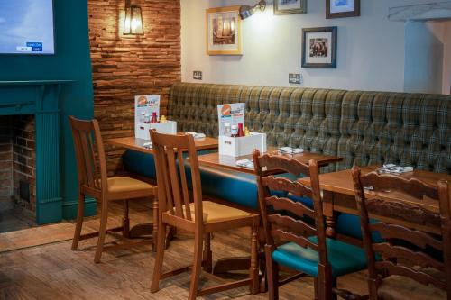 a table in a restaurant with chairs and a couch at Lodge at Solent in Fareham
