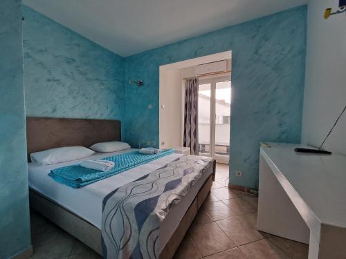 a bedroom with a bed with a blue wall at Villa Golf 2 in Budva