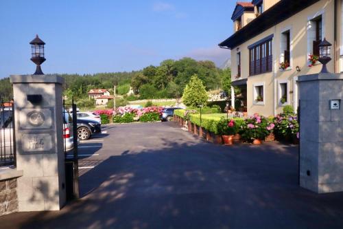 a parking lot with a bunch of flowers and a building at Casa de Aldea El Frade in Ribadesella