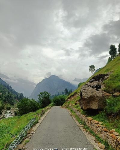 a road in the mountains on a cloudy day at Ibex Riverside Cottage Neelum Valley in Kundālshai