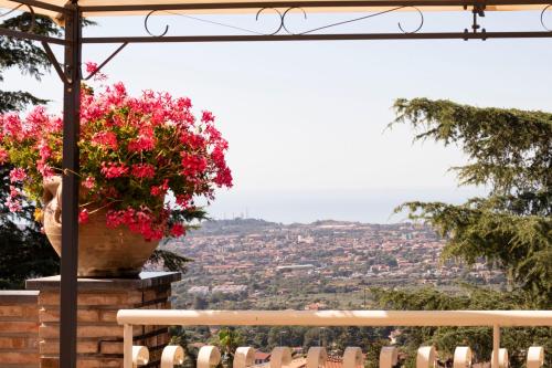 a view of a city from a balcony with flowers at Etna Royal View in Trecastagni