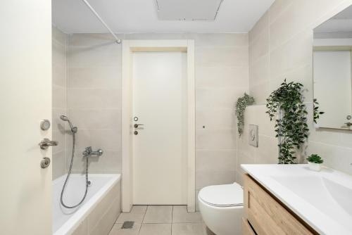 a bathroom with a tub and a toilet and a sink at Sea Breeze Netanya Retreat with Mamad by Sea N' Rent in Netanya