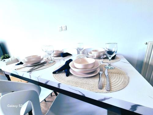 a white table with plates and wine glasses on it at Charmant T3 in Lyon