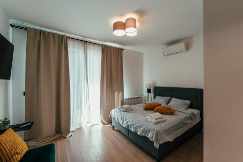 a bedroom with a bed and a large window at BW Symphony Suites in Belgrade