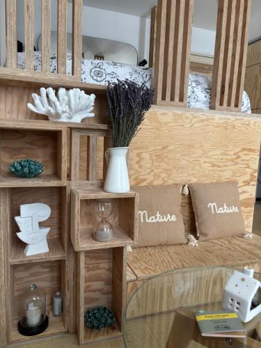 a wooden shelf with pillows and a vase on it at Eden Studio in Ajaccio