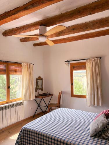 a bedroom with a bed and a ceiling fan at Casa Les Germanes in Gramuntell