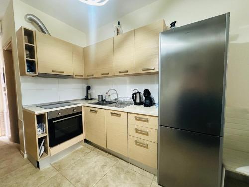Una cocina con refrigerador de acero inoxidable y gabinetes de madera. en A&B Villa Nea Fokea, en Nea Fokea