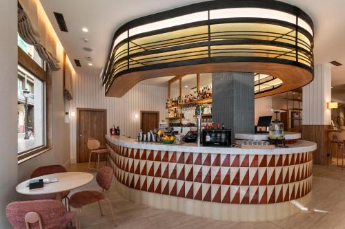 a bar in a restaurant with tables and chairs at Catalonia Excelsior in Valencia