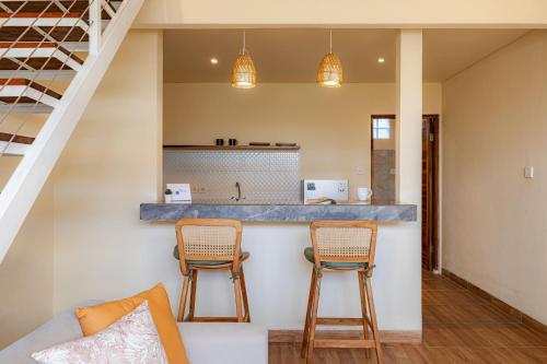 a living room with two chairs and a counter at Cove Lotus Lofts Seminyak in Seminyak